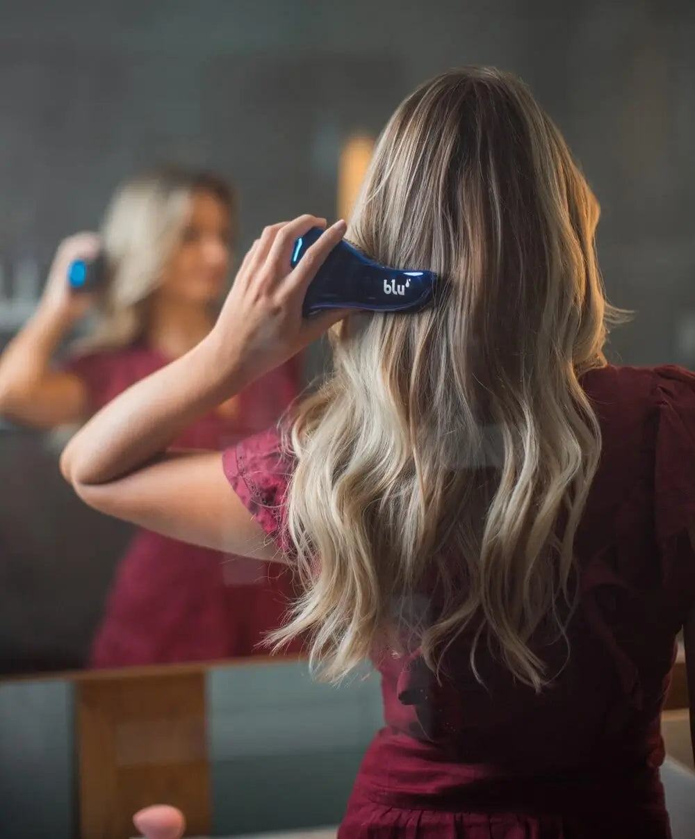 Blonde female brushing hair using the blu tangle-free brush